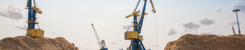 Industriekräne bei Holzspäne-Haufen im Freien