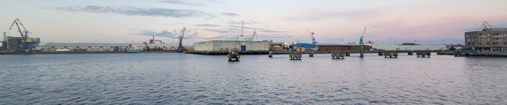 Hafen mit Kränen am Abendhimmel.